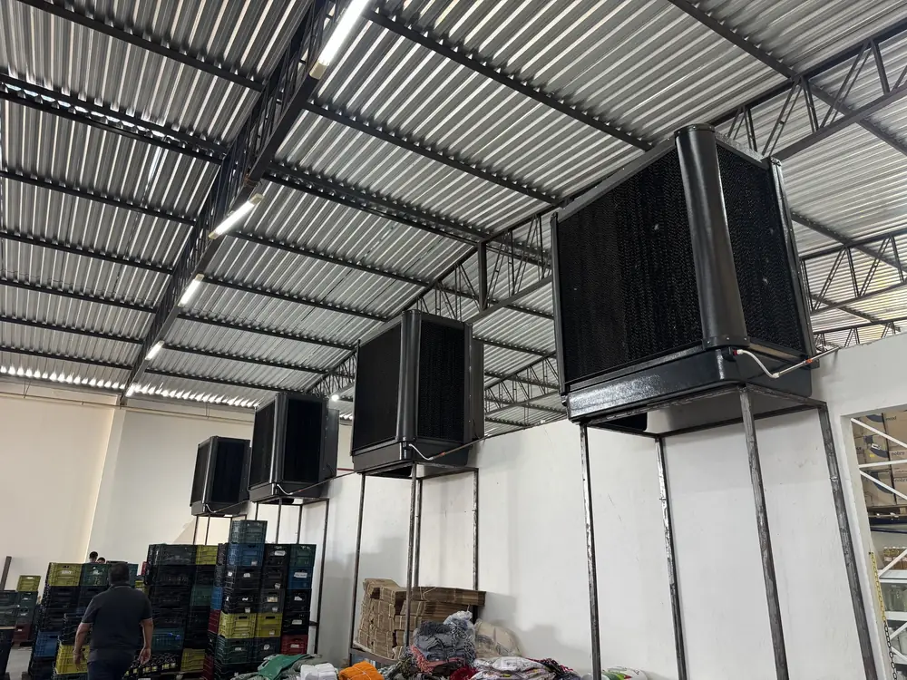 Climatizadores industriais pretos instalados no alto de um centro de distribuição